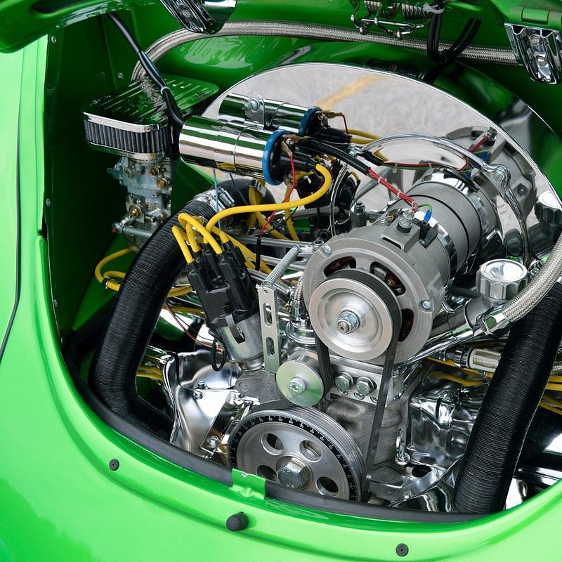 Green classic car with detailed chrome engine bay and yellow spark plug wires