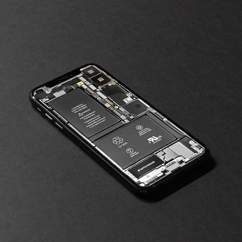 Smartphone with internal components exposed on dark background