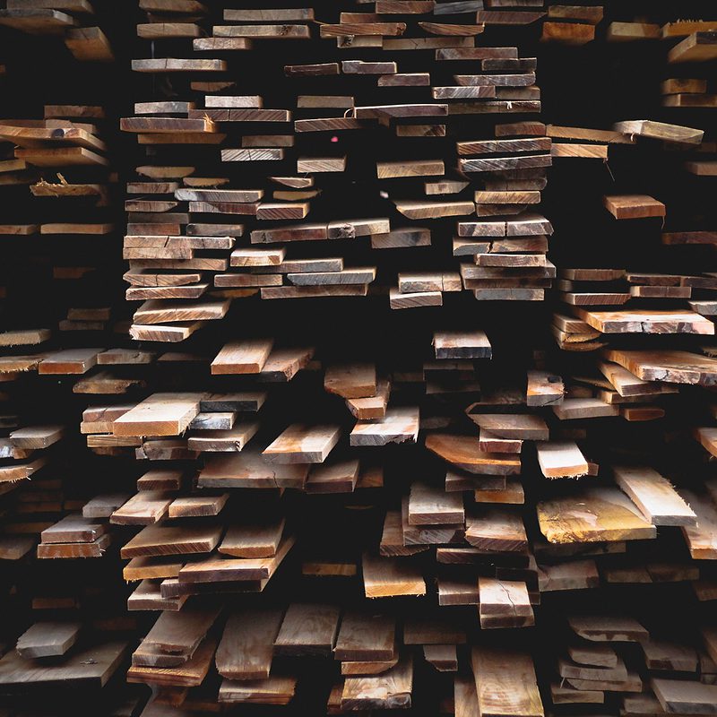 Stacked wooden planks in a haphazard pattern creating an abstract texture