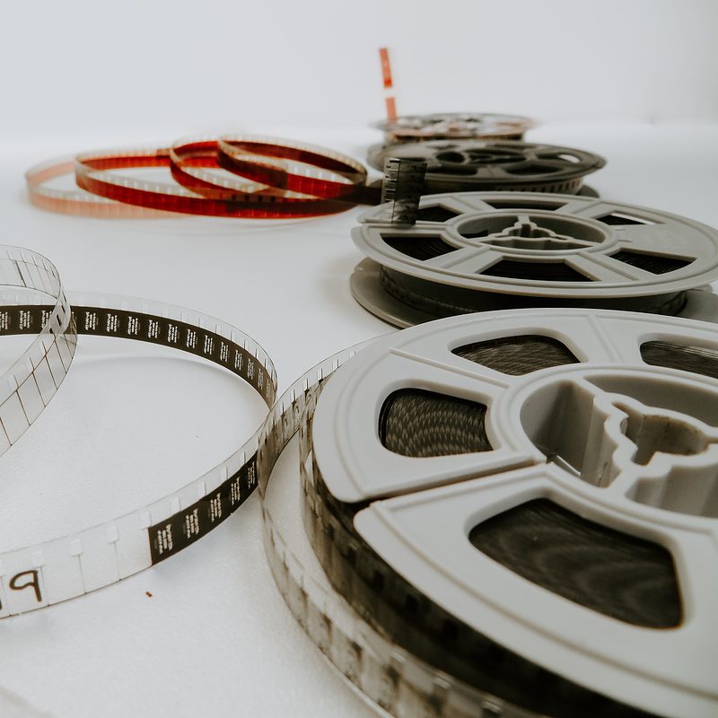 Vintage film reels and exposed film strips on a white background
