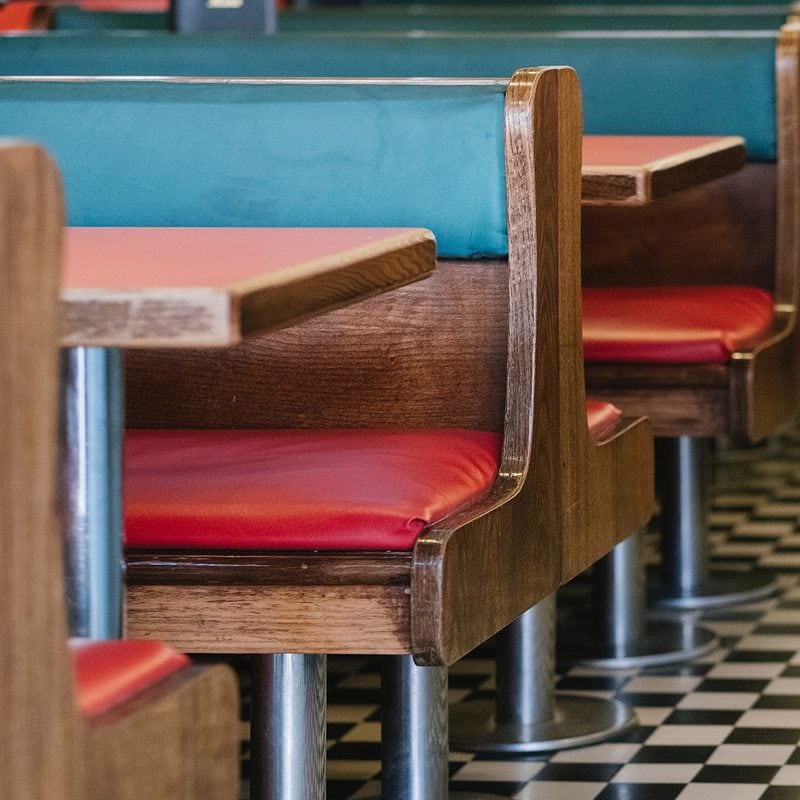 Vintage diner interior with red seats and black and white checkered floor.