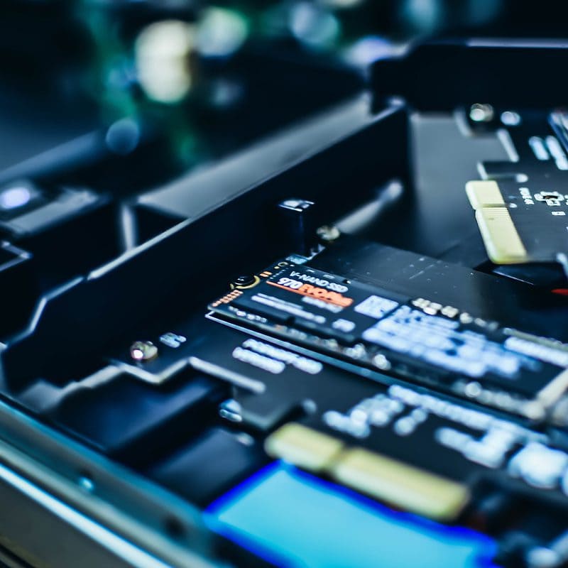 Close-up of SSDs installed in a computer motherboard with red lighting.