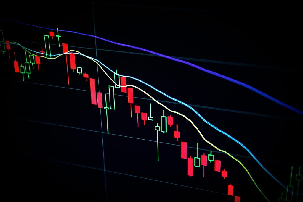 Candlestick chart on a dark background indicating stock market downtrend with moving averages