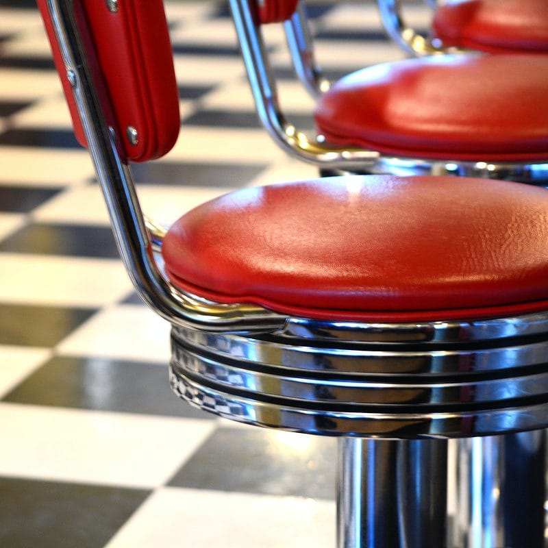 Red retro diner stools on black and white checkered floor