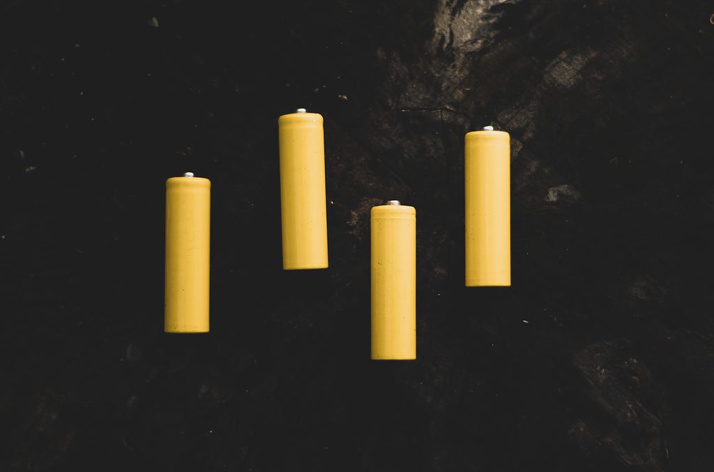 Five unlit yellow candles on a dark background