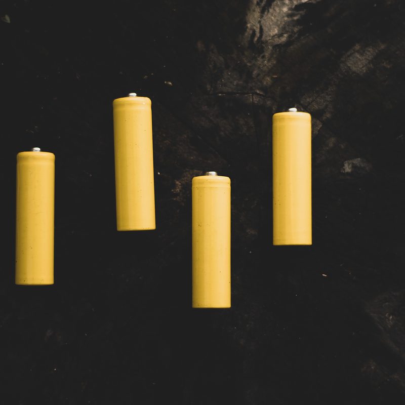 Five unlit yellow candles on a dark background
