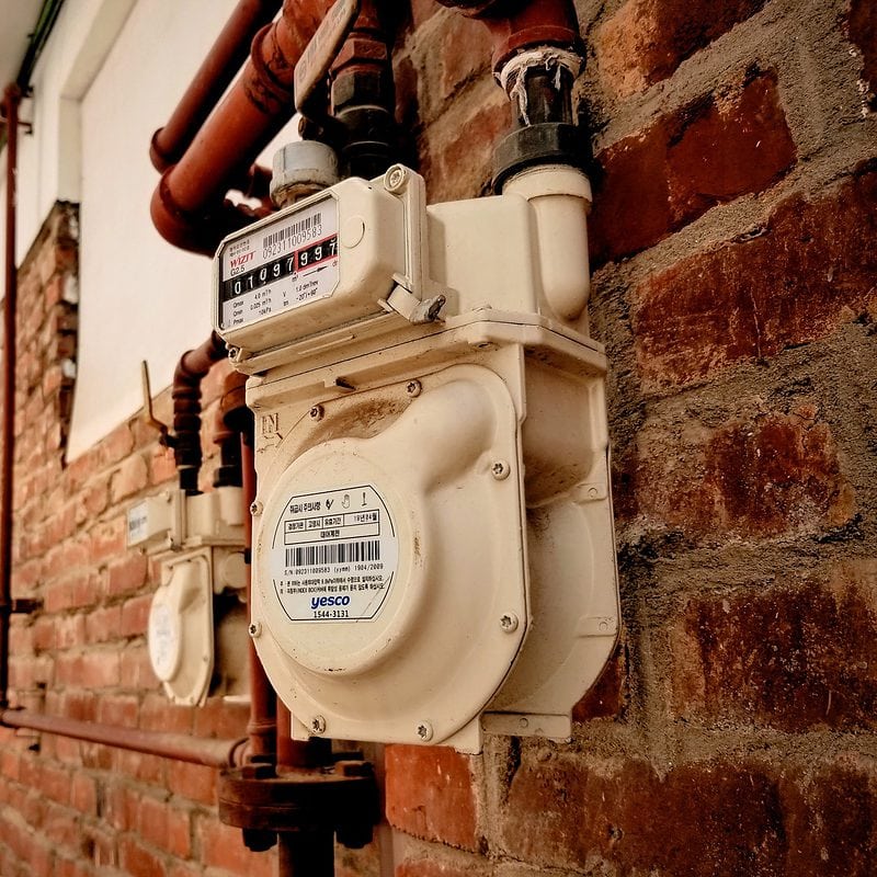Gas meters on a brick wall in a narrow alleyway