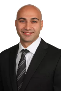 Bald man in suit with striped tie and confident smile