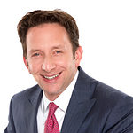 Smiling businessman in suit with red tie on white background