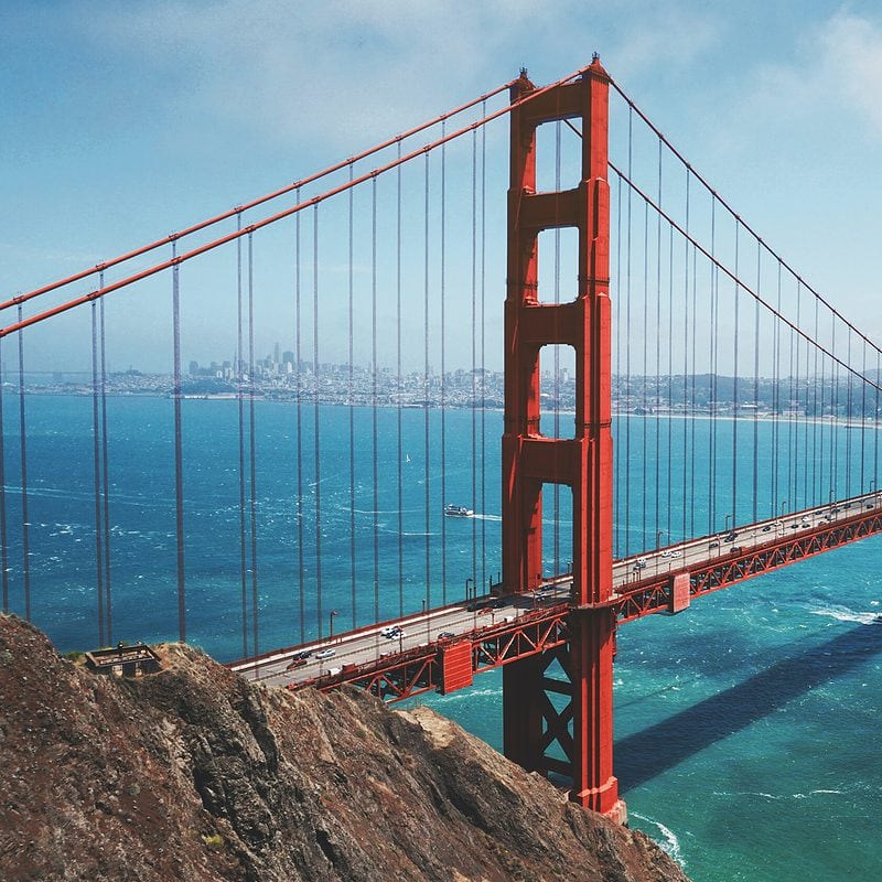 Golden Gate Bridge spanning blue waters with San Francisco skyline in distance
