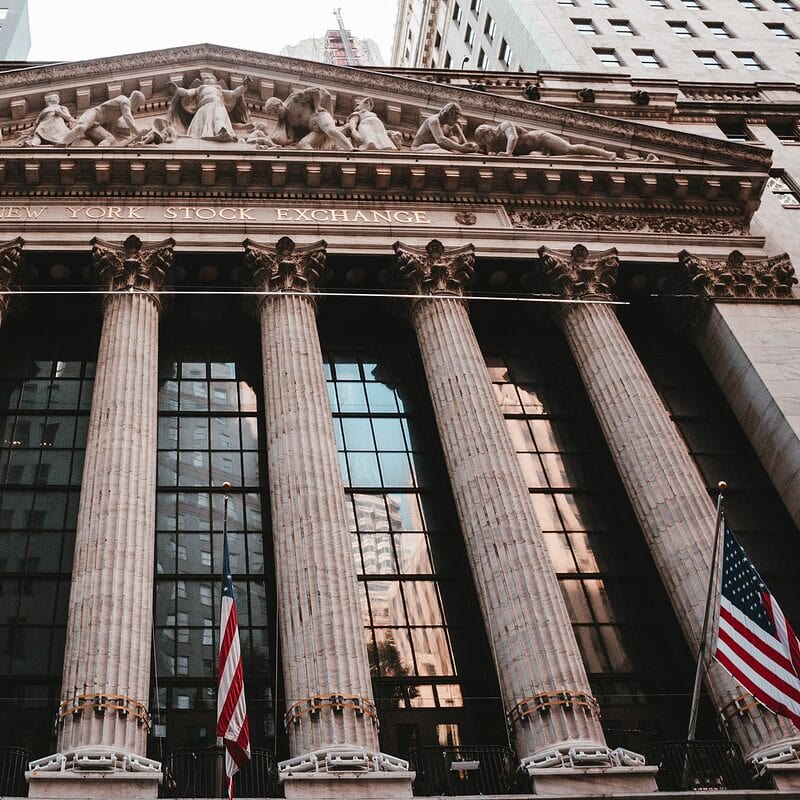 Facade of New York Stock Exchange with US flags and columns