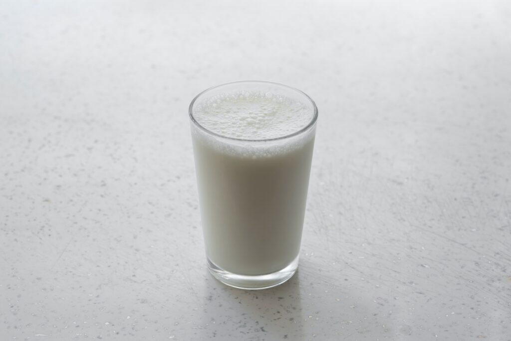 Fresh glass of milk on a white speckled surface