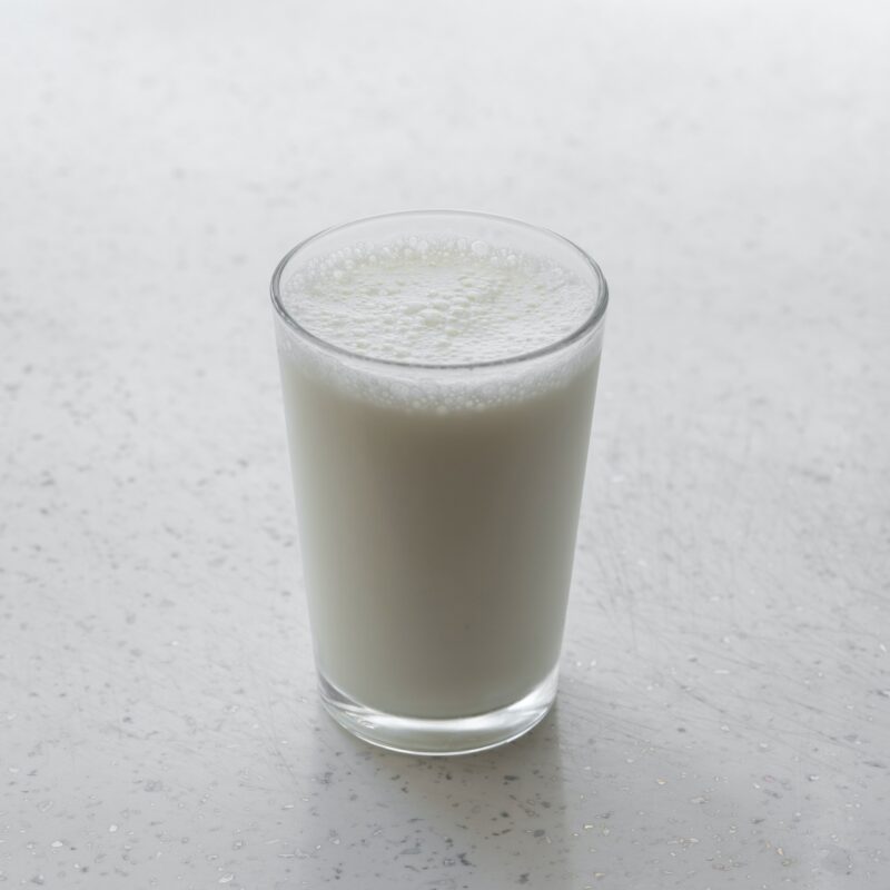 Fresh glass of milk on a white speckled surface