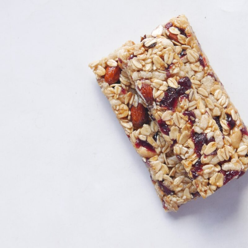 Close-up of a cranberry almond granola bar on a white background